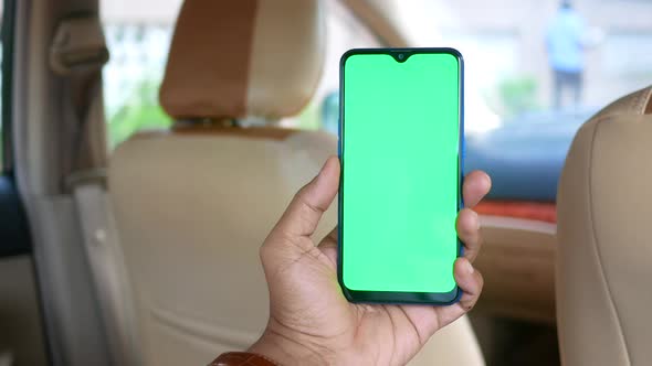 Young Man Hand Using Smart Phone with Green Screen in a Car