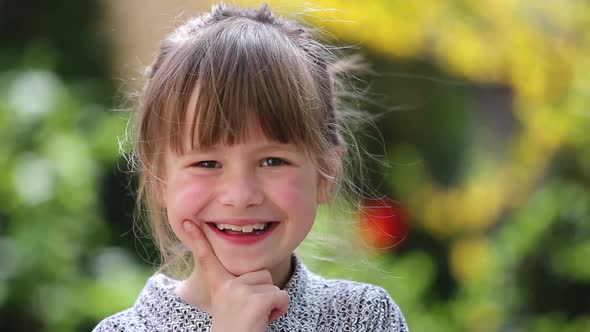 Portrait of Happy Smiling Child Girl Outdoors in Summer