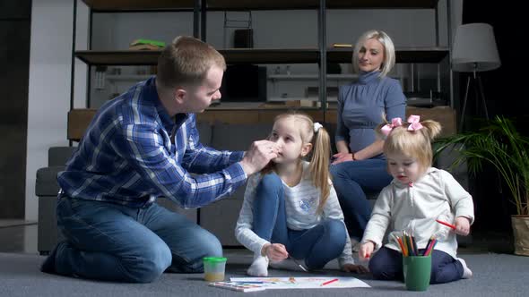 Caring Dad Wiping Paint Off Preschool Girl's Nose