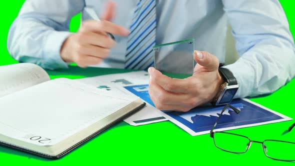 Businessman using digital smartphone while working