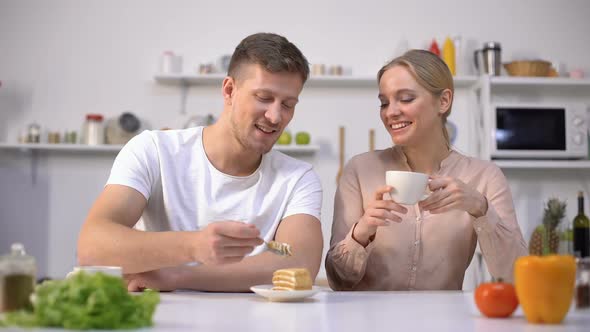 Handsome Man Feeding Girlfriend With Cake, Date in Kitchen, Romantic Atmosphere