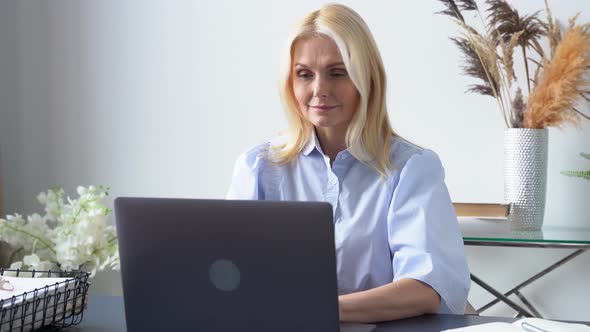 Middle Aged Woman Working Online Using Laptop Typing on Computer