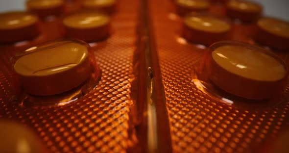 Round Medical Pills in Orange Blister Closeup