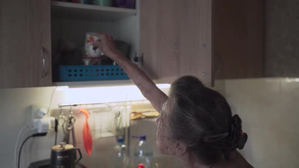 Senior Elderly Woman Washing Dishes in Kitchen