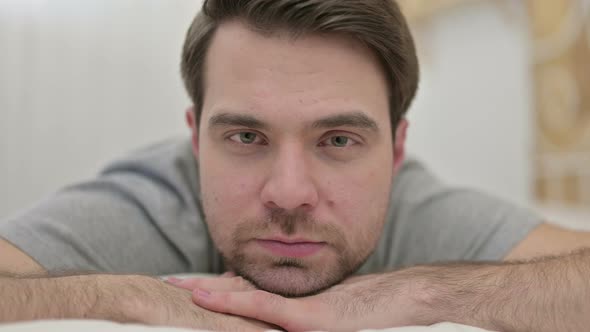 Close Up of Beard Young Man Looking at Camera in Bed