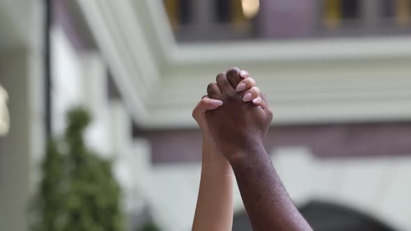 Black Man and the White Woman Raised Their Hands Clenched Together Into a Fist. Black Lives Matter