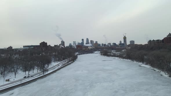 Mississippi River completely  frozen close to downtown minneapolis during a cloudy cold winter after