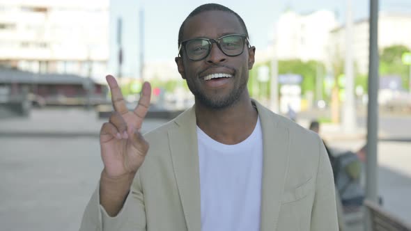Excited African Man Showing Victory Sign Outdoor