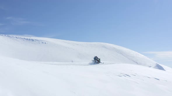 Snowboarders Driving on Snowmobile on Winter Mountain Highlands at Winter Day