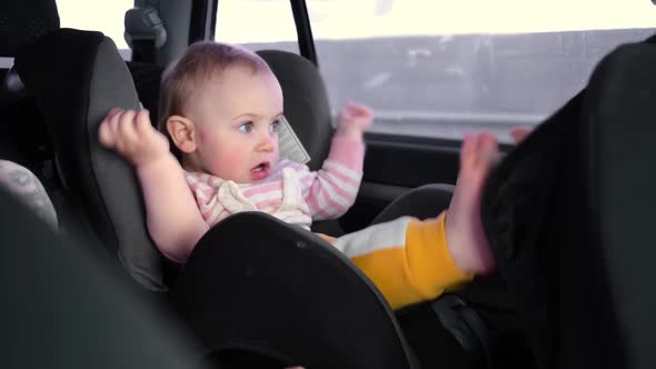 Little Girl Sitting in Baby Car Seat While Car is Driving