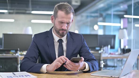 Shocked Young Businessman Getting Upset on Smartphone