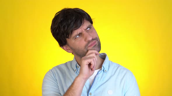 Pensive Man Looks Around Thinks Scratches at Temple Comes Up with Ideas Raised Finger Up Isolated on