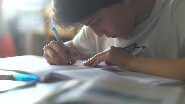 Boy writing on book