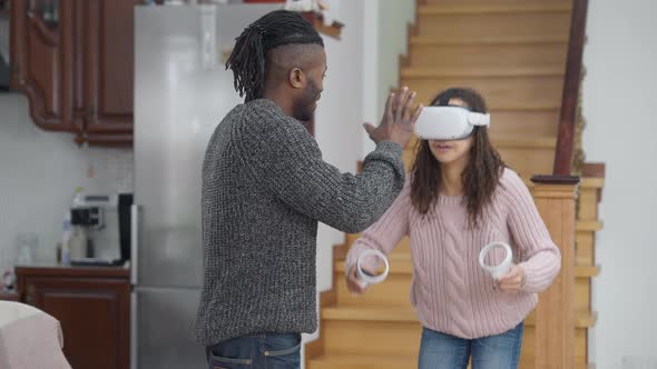 Father Moving Hand in Front of Face of Absorbed Daughter Gaming Online in Augmented Reality Turning