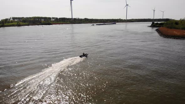 Aerial Tracking Shot Of Speedboat Travelling Across Calm Waters Of Oude Maas