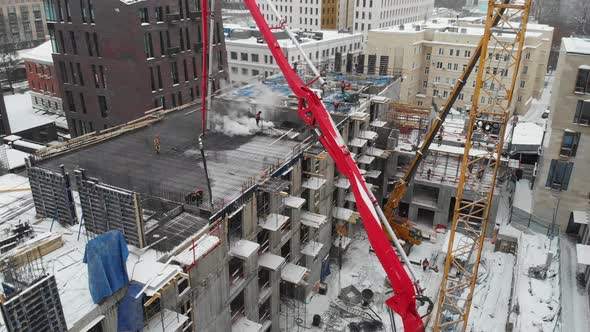 Truckmounted Concrete Pump Works on the Construction of a Residential Complex in the Winter in the