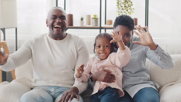 African Afro Family Happy Parents and Little Black Child Girl Sitting at Home Sofa Laughing Loudly