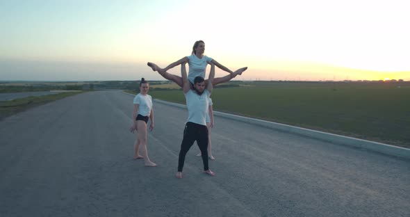 Young Athletes Posing Man Is Holding Woman Who Is Doing a Split Film Grain