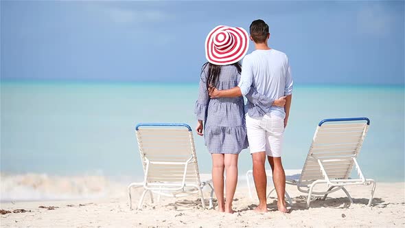 Young Couple on White Beach During Summer Vacation. Happy Family Enjoy Their Honeymoon