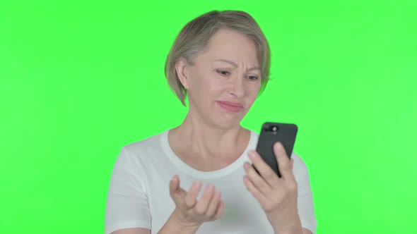 Old Woman Loss on Smartphone on Green Background