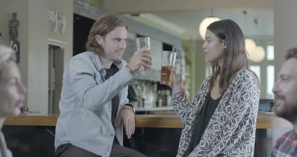 Man and woman enjoying beer and talking in pub