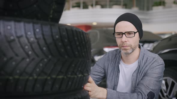 A Man Chooses Tires for His Car