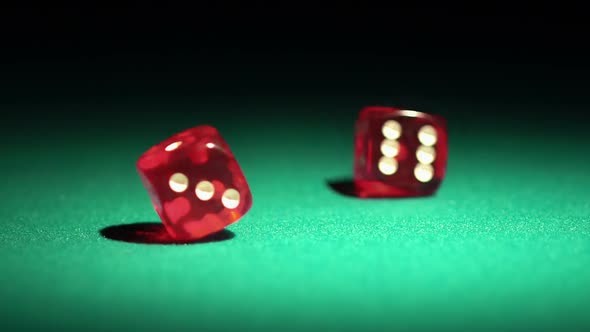 Red Casino Dice Rolling on Green Table in Slow Motion