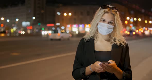 Lady Wears Protective Facial Mask Holding Modern Smartphone