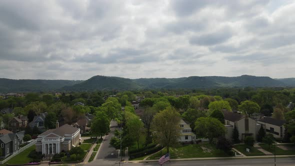 Aerial view of well established community at base of mountains with gray cloudy sky.