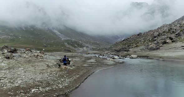 Aerial View of a Young Man Running Along Pristine Mountain Landscape