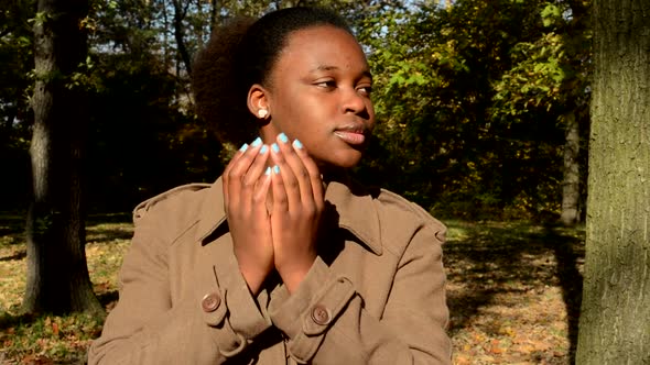 Young Happy African Girl Stands in Woods, Takes Hands Off From Face, Looks Around and Is Surprised