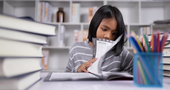 Asian short hair girl reading at the desk at classroom.