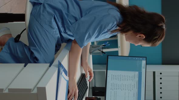 Vertical Video Woman Working As Nurse with Computer and Documents