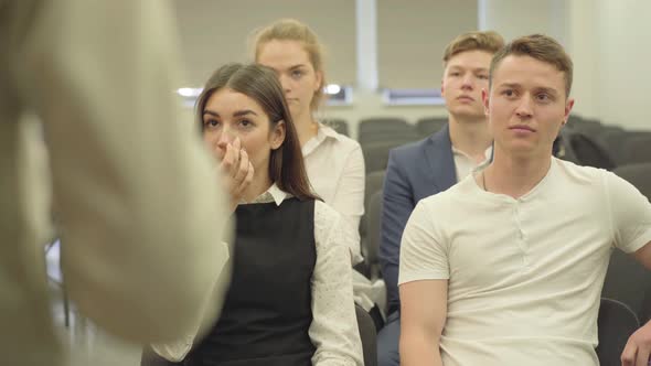 Four Young Male and Female Managers in Formal Wear Listening To the Lecturer Sitting in the Small