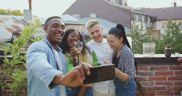 Mixed Race Friends Making Selfie During Meeting in Somebody's Home on Terrace at Summertime