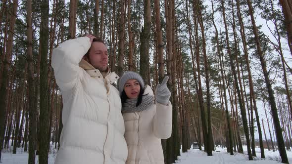 The Girl Points Her Hand at Something to the Guy