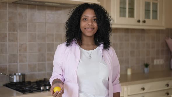 Medium Shot Portrait Smiling Charming African American Young Woman Juggling Lemon Looking at Camera
