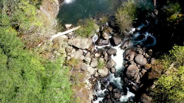 Drone footage looking down while moving with the flow of water above a double tiered water fall at C