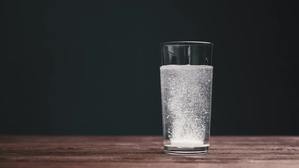 Effervescent Aspirin Pill Falling Into a Glass of Water