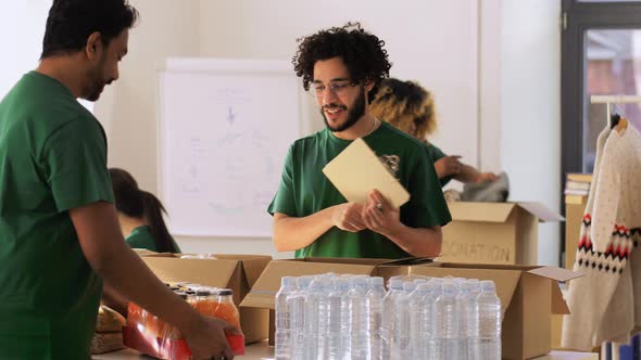 Group of Volunteers Packing Food in Donation Boxes