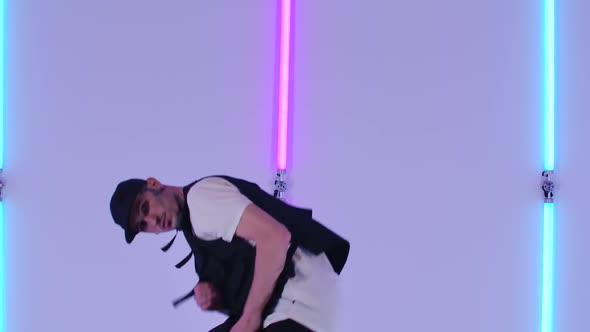 Professional Hip Hop Dancer Practicing Street Dance Elements Against Bright Neon Lights in Studio