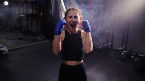 Female Boxer Looking at the Camera in Bandages and Screaming