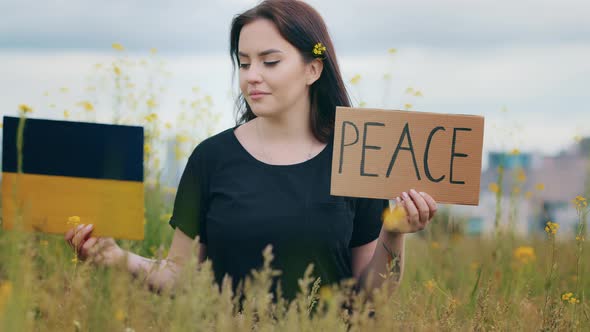 Unhappy Lady Brunet Woman Activist Pick Up Two Paper Banners with Inscription Peace Cardboard in