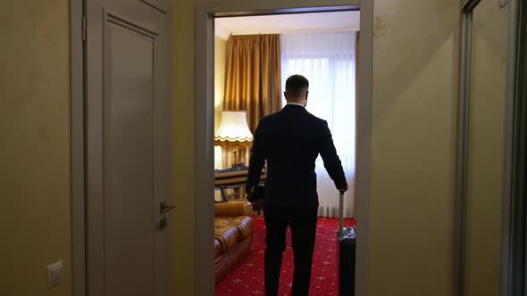 Handsome man walking in a hotel room after business meeting. 