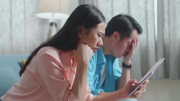 Couple With A Laptop Holding Credit Card And Smartphone Having Headache Due To Unable Pay Money