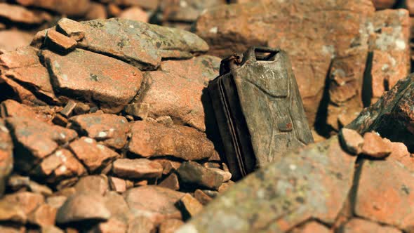 Old Rusty Metal Canister for Gasoline Fuel at Rocks alt