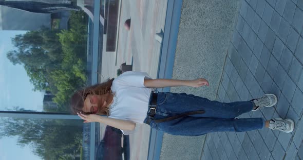 Stylish Girl Dancing Staging Front Camera Outdoors at Modern Glassy Building