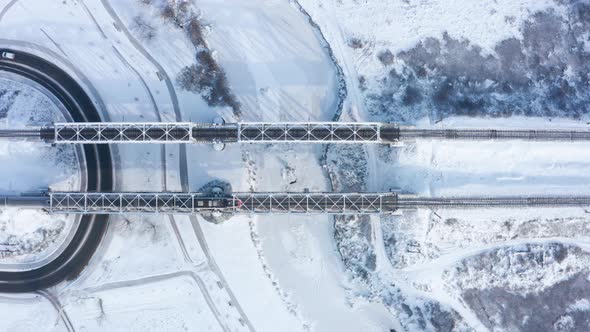 Fast electric train passes over the railway bridge in winter