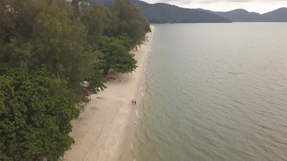 Aerial view people walk at sandy beach
