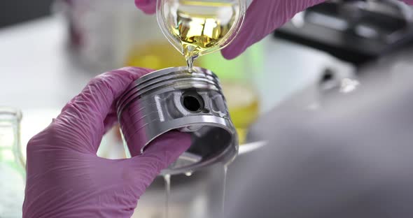 Scientist Chemist Pouring Engine Oil on Piston of Car in Laboratory Closeup  Movie Slow Motion